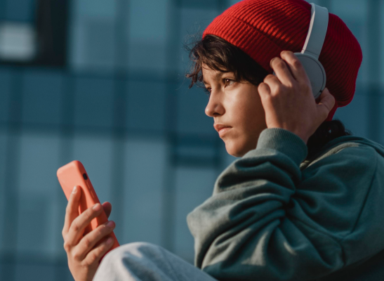 teenager listening music headphones while using smartphone